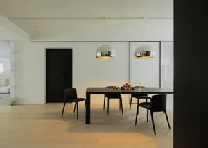 Modern minimalist dining room with metal and wood furniture, tiled flooring, and metallic pendant lights.