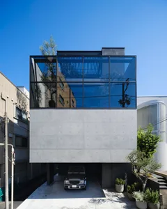 A modern house featuring large glass windows and a concrete facade.