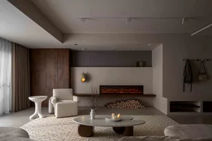 A modern minimalist living room with a white armchair, coffee table, and fireplace.