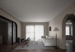 A minimalist living room with neutral-toned decor and a glass coffee table.