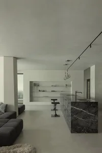 A minimalist kitchen with a marble countertop and island.