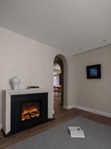 Modern interior living room with a concrete fireplace and arched doorway.