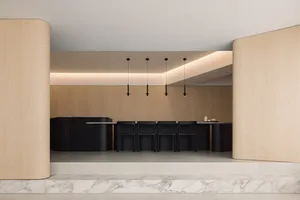 Modern kitchen with wooden countertop and chairs.