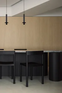A modern kitchen with wooden cabinets and a marble countertop and floor.