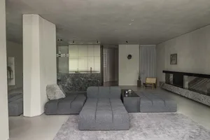 A modern living room with concrete and marble materials