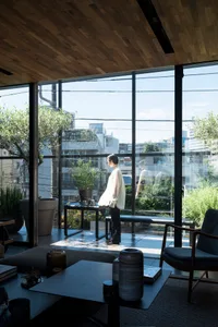 A modern living room with glass windows and minimal furniture.