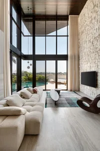Modern living room designed with stone, concrete, and glass materials.