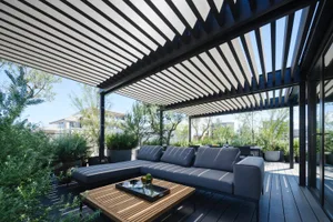 A modern patio space featuring wooden furniture and minimalist design, with a comfortable seating area and potted plants.