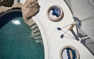A modern residential patio featuring a concrete surface, glass elements, and blue decoration.