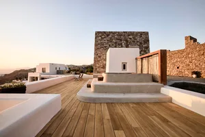 A modern residential patio featuring concrete structures, stone walls, and wooden flooring.