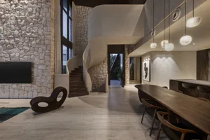 Modern living room interior with concrete flooring, minimalist decor, and large windows.
