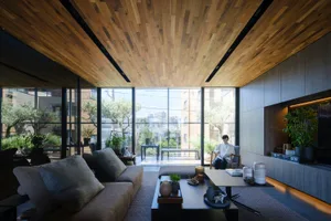 A modern living room with a wooden ceiling, large windows, and a comfortable sofa.