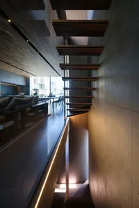 A modern residential interior featuring a wooden staircase and open-plan living space.