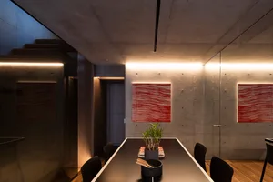 Modern minimalist conference room with concrete walls and minimalist art.
