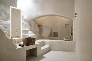 Modern bathroom interior designed with stone elements, featuring a sink, mirror, and textured walls.