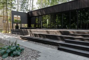 A modern residential exterior featuring a combination of wood and glass materials.
