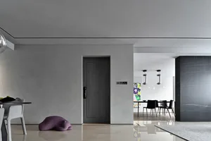 A minimalist living room featuring concrete walls and glass elements.