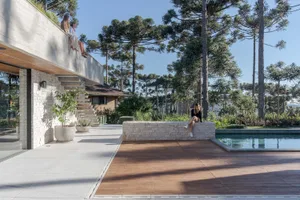 A minimalist residential exterior features concrete, glass, and wood materials.