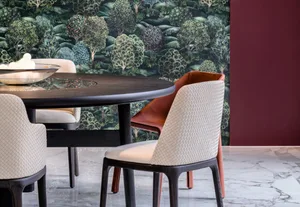 Modern dining area featuring a wooden table and upholstered chairs with a textured design against a wallpaper with tree patte