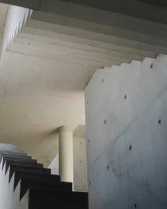 A modern industrial interior space with concrete walls and ceiling.