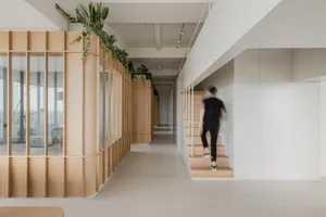 A modern interior design corridor with wooden stairs and walls, featuring greenery along the ceiling.