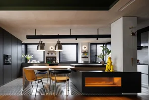 A modern kitchen featuring metal furnishings and ceramic tiles with a black and white checkered pattern, illuminated by penda