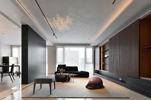 A modern living room with concrete walls, a black sofa, and a wooden coffee table.