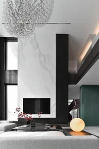 A modern living room with marble walls and a concrete fireplace.