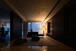 現代簡約客廳採用混凝土飾面，搭配黑色沙發、咖啡桌與立燈。