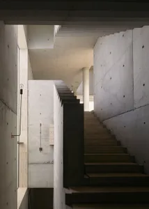 A modern interior featuring a monolithic staircase made of concrete.