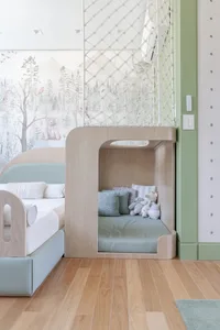 A minimalist children's bedroom featuring a modern design with a natural wooden bed frame and a cushioned hidden nook for pla