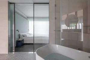 Modern bathroom featuring a glass shower enclosure and a freestanding bathtub.