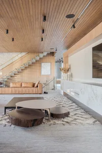 A modern living room featuring wood, marble, and concrete materials