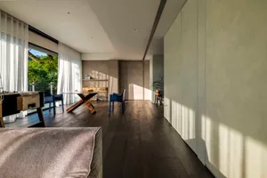 Contemporary living room with wooden floor and white curtains.