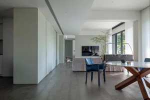 Modern living and dining room with minimalist decor and furniture.