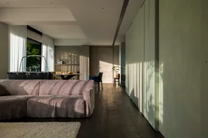 A modern living room featuring a comfortable couch, a foosball table, and a sleek design aesthetic.