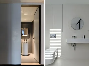 A modern minimalist bathroom featuring a sleek, white toilet and sink, with white materials and a minimalist design.