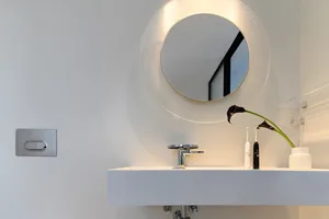 Modern minimalist bathroom with ceramic sink and mirror.