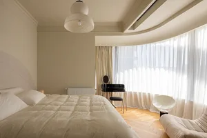 A minimalist bedroom with neutral tones and soft lighting.