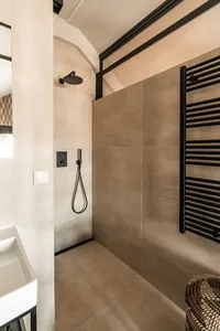 Modern bathroom with concrete tiles, black rail, and minimalist design.