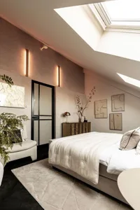 A modern bedroom featuring a bed with a fabric-covered headboard and footboard, a beige upholstered bench, and a decorative p