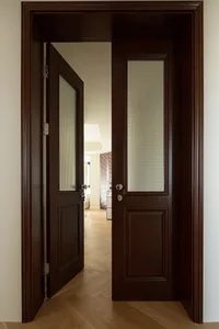 An open wooden door with glass panels leading into a residential interior.