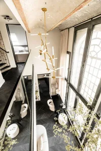 Modern interior space featuring black and white lighting fixtures, large windows, and white curtains.