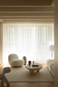 A modern living room with neutral-toned furniture and minimalist design.