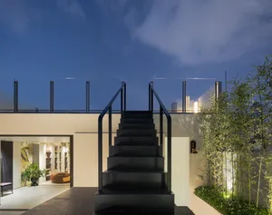 Modern black staircase with metal railings and glass walls, featuring a clean, minimalist design.
