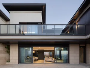 Modern house with glass exterior and rooftop balcony overlooking cityscape.