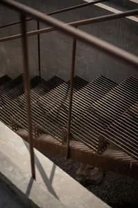 Industrial metal staircase with a metallic finish and grating design.