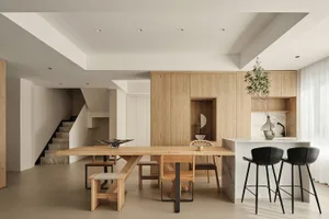 A spacious, modern kitchen with wooden furniture and a marble countertop.