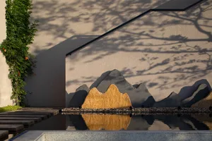 Modern landscape design featuring a contemporary water feature with concrete and stone elements.