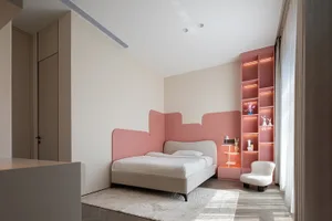 A modern bedroom featuring a pink bed, white chairs, a pink bookshelf illuminated by lights, and white curtains.